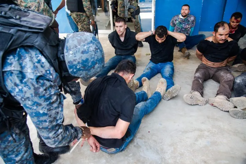 ARRESTOS. Policías custodian el jueves 8 de julio a un grupo de sospechosos de haber participado en el asesinato del presiden
