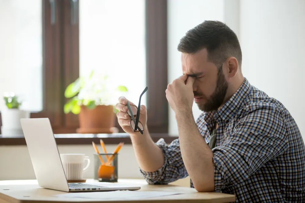 Hombre estresado por el trabajo frente a computadora