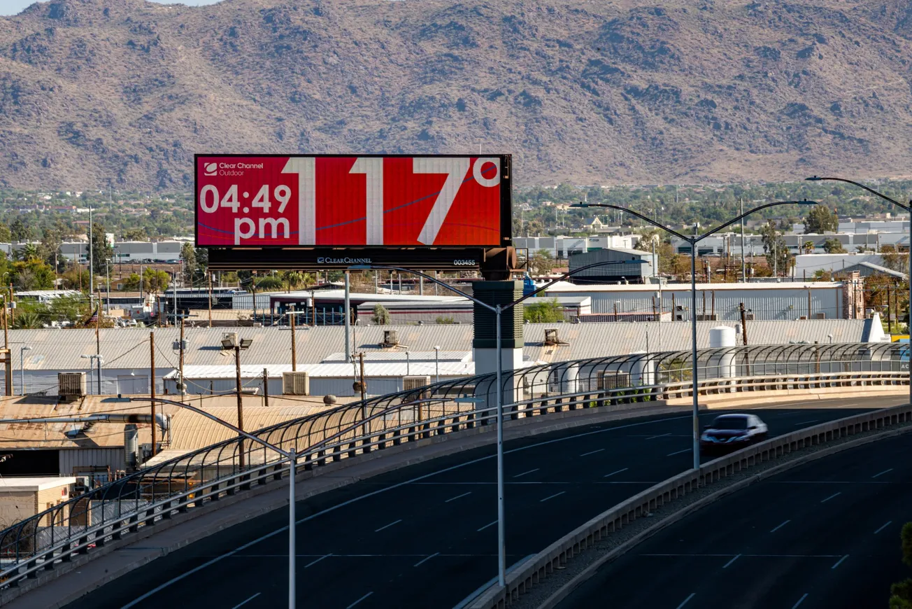 Una valla publicitaria eléctrica muestra una temperatura de 117 grados Fahrenheit a los automovilistas mientras viajan en Pho