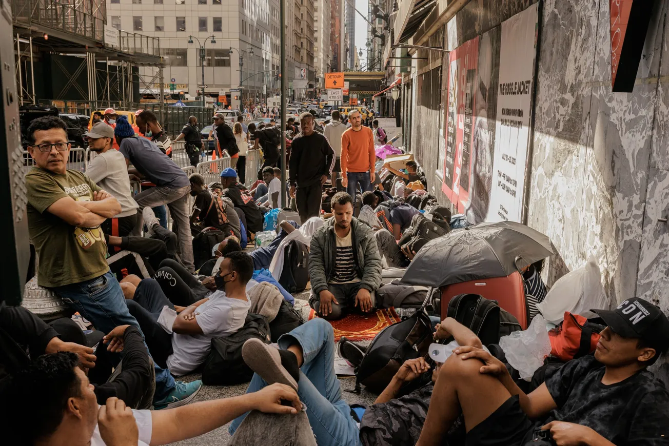 Migrantes esperando a ser procesados fuera del Hotel Roosevelt en Manhattan, el martes 1 de agosto de 2023. (Jeenah Moon/The