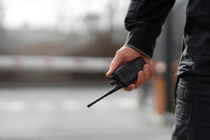 Imagen referencia de un policía con radio en en la mano